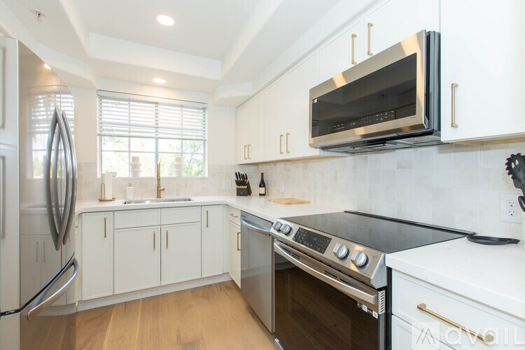 A modern kitchen with white cabinets and stainless steel appliances.