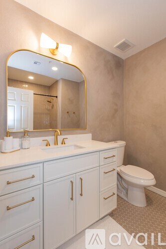 A bathroom with a sink, toilet and mirror.