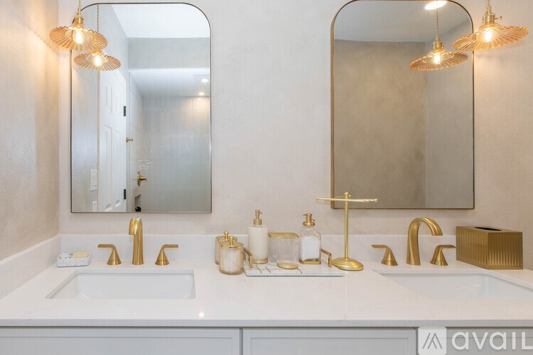 A bathroom with a white countertop and gold fixtures.