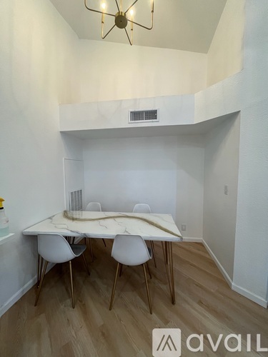 A dining area with a white table and chairs.