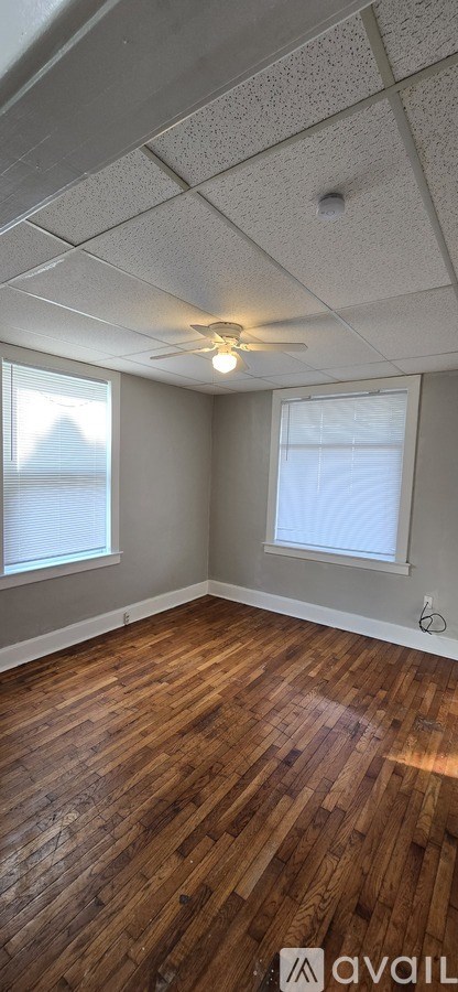A room with wooden flooring and a ceiling fan.