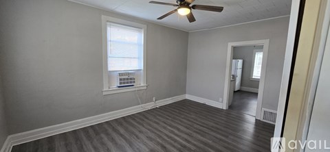 A room with a ceiling fan and a window.