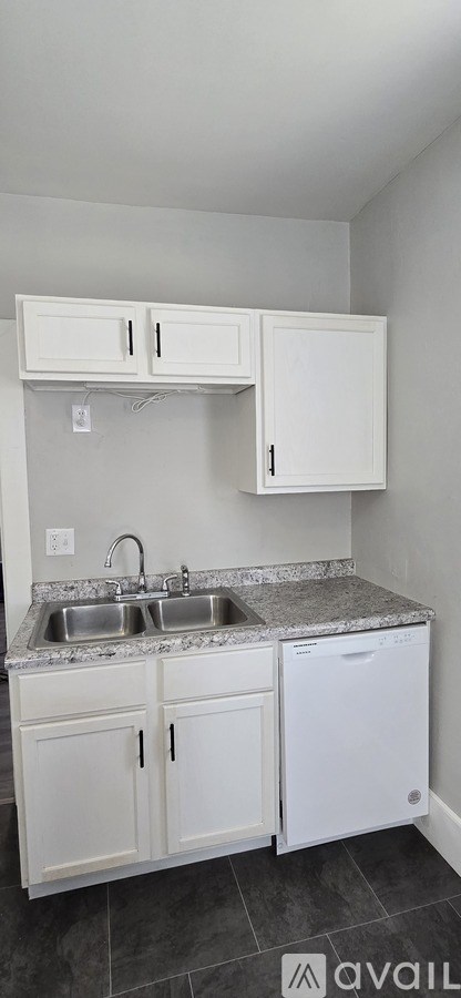 A kitchen with white cabinets and a granite countertop.