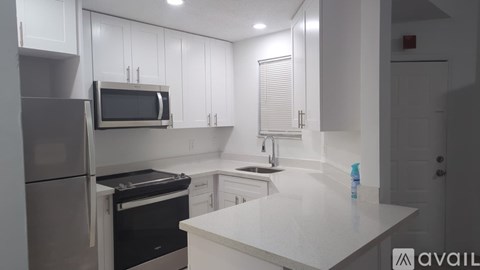 A kitchen with white cabinets and appliances.