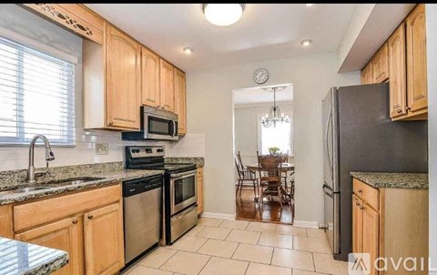 A kitchen with wooden cabinets and black appliances.