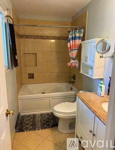 A bathroom with a bathtub, toilet, and a sink.