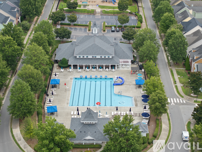 An aerial view of a swimming pool surrounded by trees and a building.