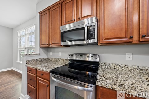 A kitchen with wooden cabinets and granite countertops.