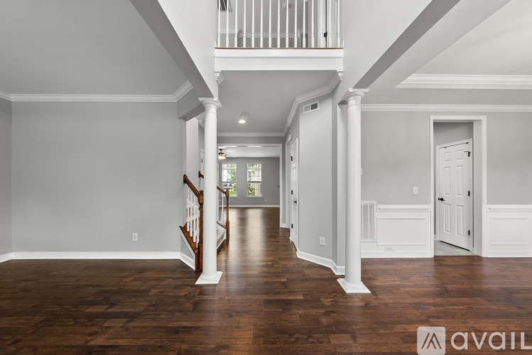 A spacious room with wooden floors and white walls.