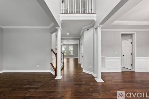 A spacious room with wooden floors and white walls.