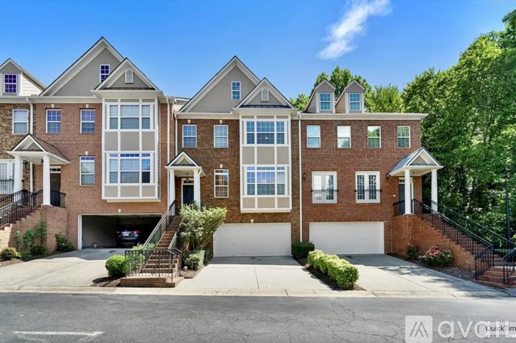 A row of townhouses with garages and front yards.