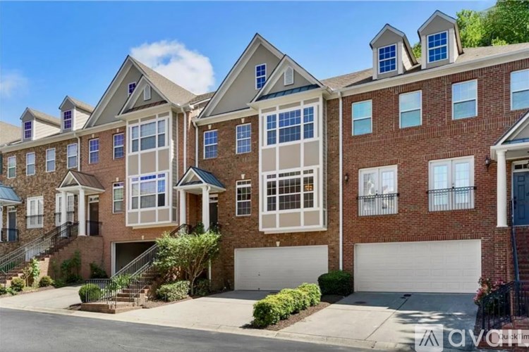 A row of houses with garages and driveways.