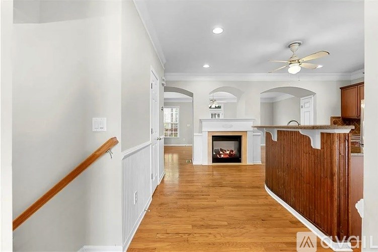 A spacious living room with a fireplace and wooden floors.