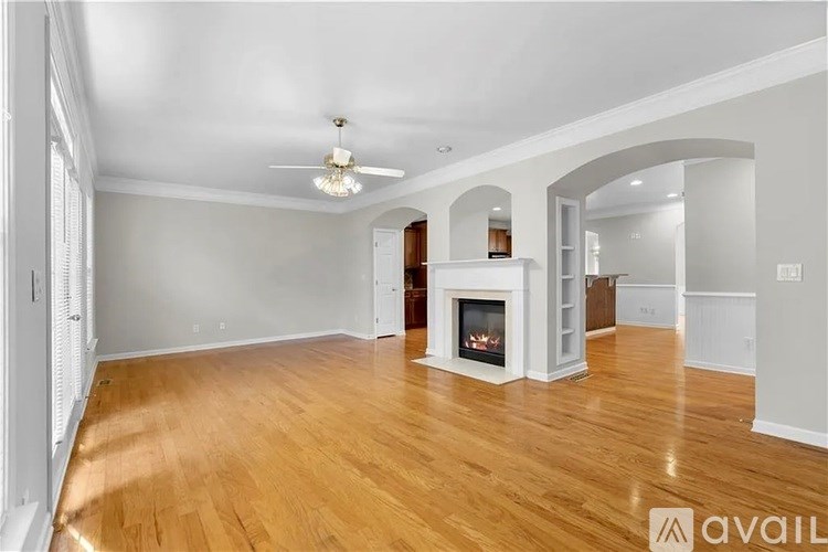 A spacious living room with a fireplace and hardwood floors.