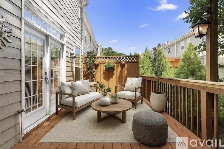 A wooden deck with a sofa, chairs, and a coffee table.