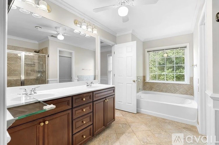 A bathroom with a large mirror, two sinks, and a bathtub.