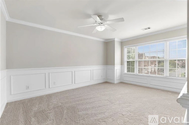 A room with a ceiling fan and a window with blinds.