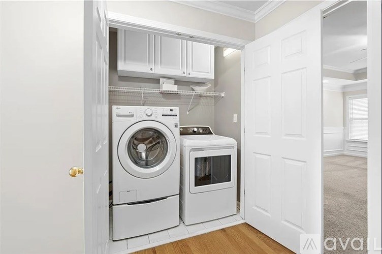 A white washing machine and dryer in a laundry room.