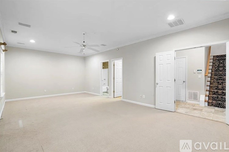 A spacious room with a fan and two doors.
