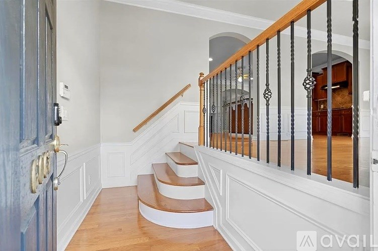 A staircase with a wooden handrail and white walls.