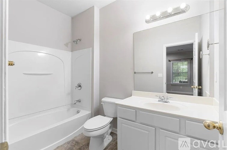 A white bathroom with a toilet, sink, and bathtub.