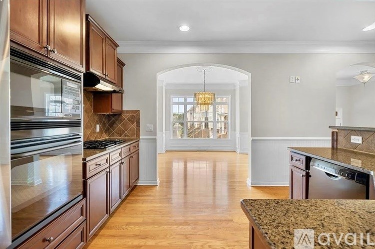 A kitchen with wooden cabinets and a granite countertop.