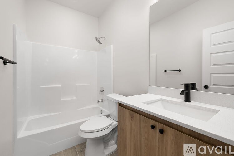A white bathroom with a toilet, sink, and shower.