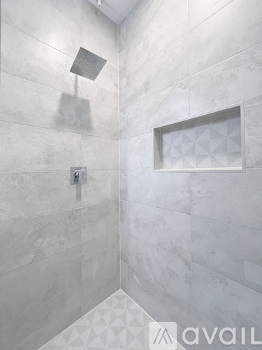 A bathroom with a shower head and a window.