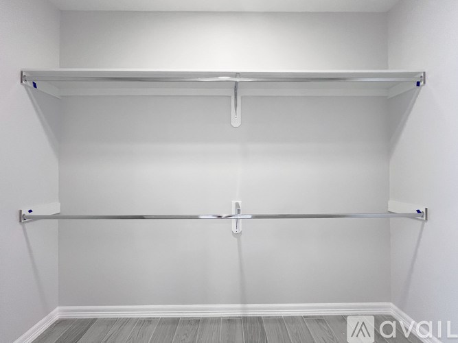 A white closet with a metal rod and a white door.