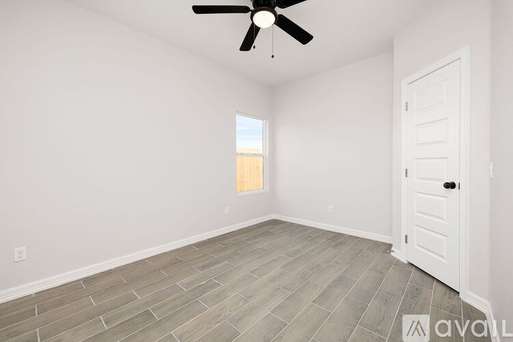 A room with a ceiling fan and a door.