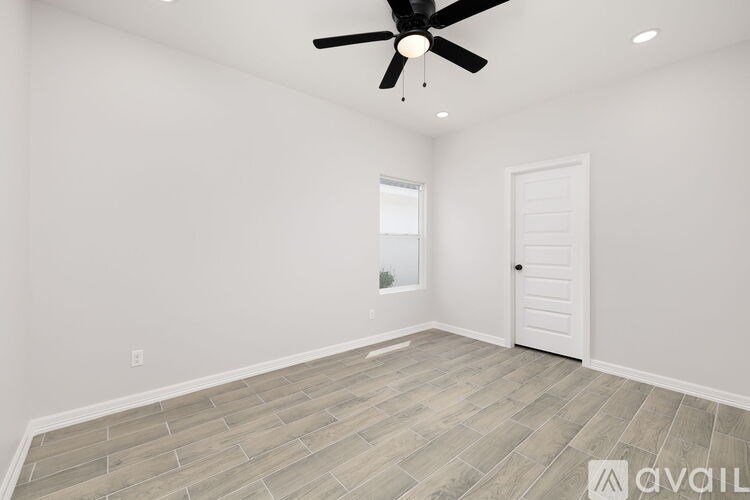 A room with a ceiling fan and a door.