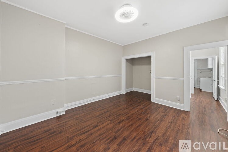A room with wooden floors and a white ceiling with a light fixture.