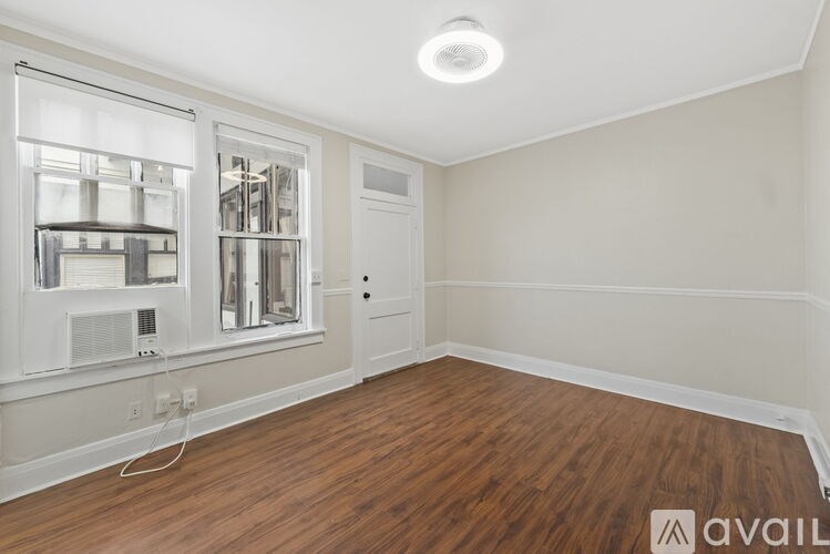 A room with a window and a door is available for rent.