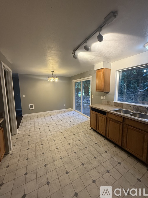 A kitchen with a tile floor and wooden cabinets.