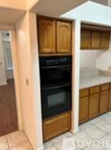 A kitchen with wooden cabinets and a black oven.
