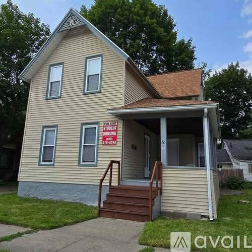 A house with a "STUDENT HOUSING" sign on the front.