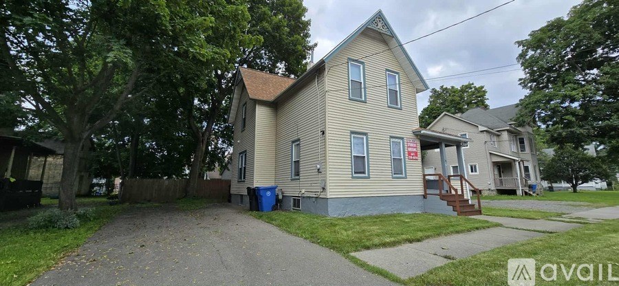 A living room with a couch, a television, and a staircase.