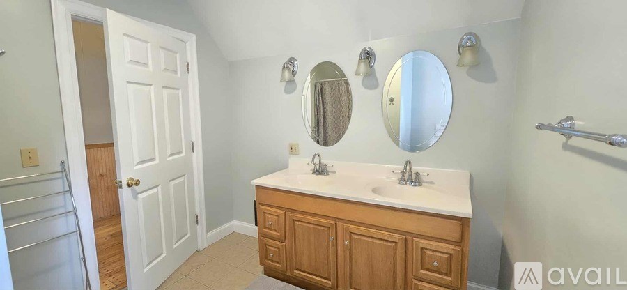 A bathroom with a white sink and a wooden cabinet.