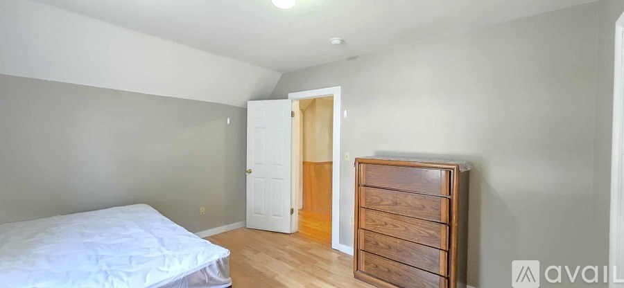 A bedroom with a bed, dresser, and closet.