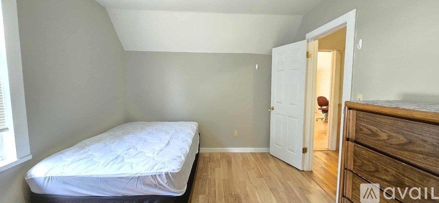 A bedroom with a bed, dresser and a window.