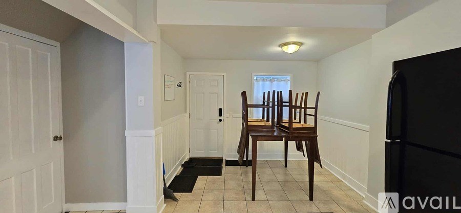A bedroom with a bed, a chair, and a mirror on the wall.