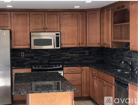 A kitchen with wooden cabinets and a granite countertop.