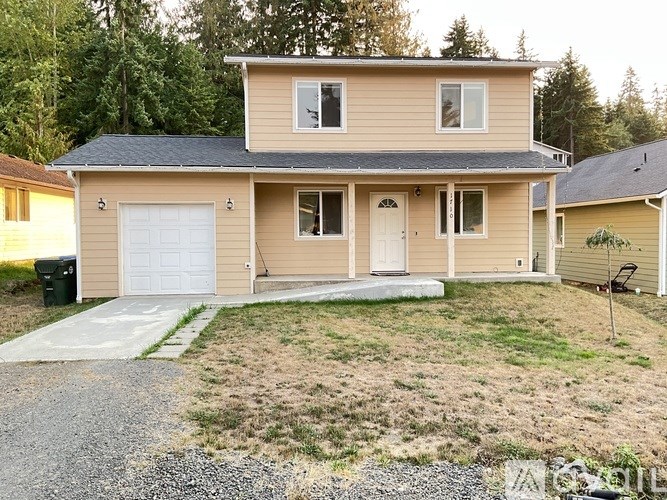 A two-story house with a garage and a driveway.