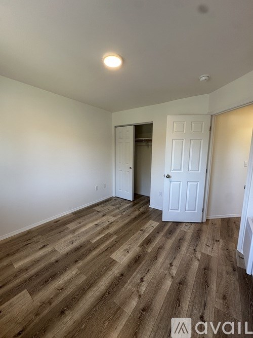 A room with wooden flooring and a white door.