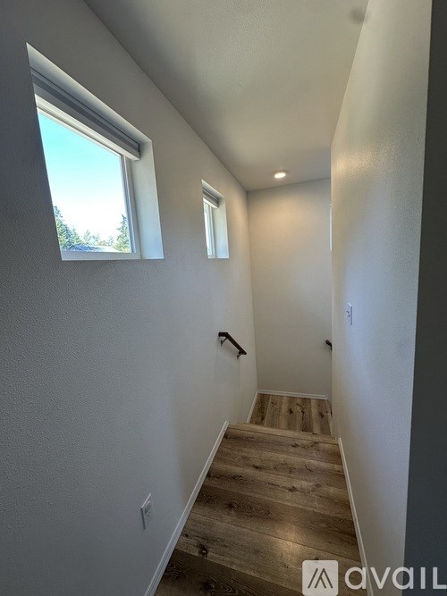 A stairway with wooden steps and white walls.