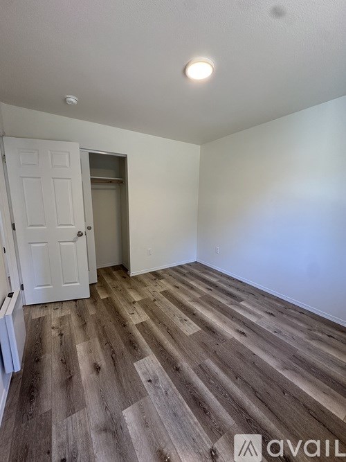 A room with wooden flooring and a white door.