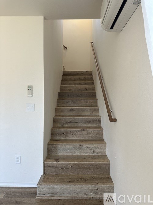 A staircase with wooden steps and a metal handrail.