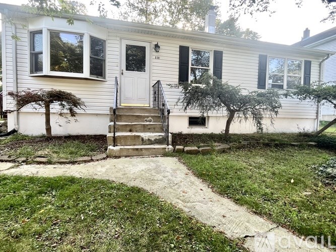 A small white house with a grey roof and a black door.