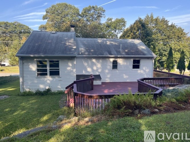 A house with a grey roof and a red deck.
