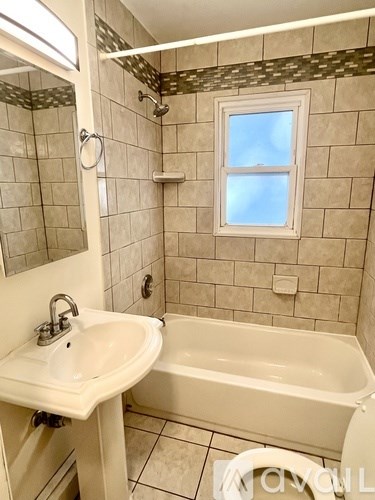 A bathroom with a white sink, tub, and toilet.